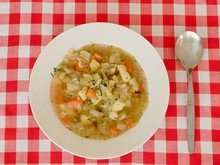 Italian Cabbage Soup In A White Plate On A Plaid Tablecloth.