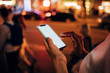 © Westend61 - Hands of woman holding smartphone at night, close-up