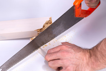 A carpenter works on a handsaw to cut a broken wooden board