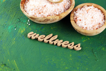 Wall Mural - Crystals of salt on table. himalayan salt in bowl and wellness letters made of wood