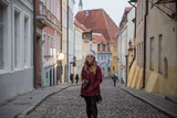 Fototapeta Na drzwi - cute female photographer walking down the old streets of telling estonia