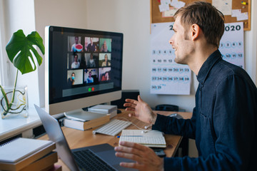 young man having video call via computer in the home office. stay at home and work from home concept