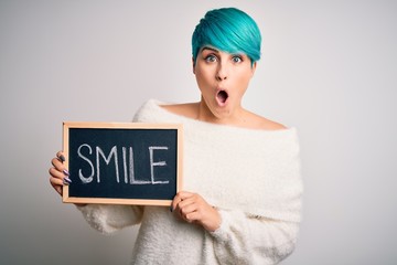 Sticker - Young woman with blue fashion hair holding blackboard with smile message scared in shock with a surprise face, afraid and excited with fear expression