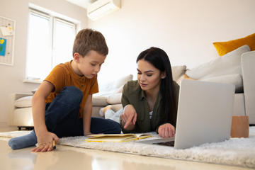 Wall Mural - Curious schoolboy studying at home during the quarantine stock photo