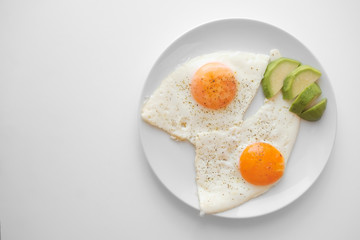 Scrambled eggs with avocado and specialy on a white plate on a white background with blank copy space, top view