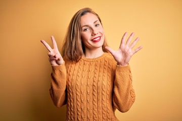 Sticker - Young beautiful blonde woman wearing casual sweater standing over yellow background showing and pointing up with fingers number seven while smiling confident and happy.