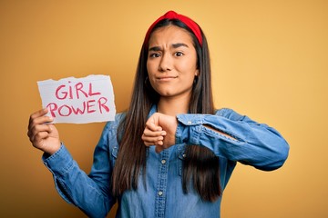 Canvas Print - Young beautiful asian woman wearing diadema holding banner with girl power message with angry face, negative sign showing dislike with thumbs down, rejection concept