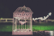 Close-up Of Empty Birdcage On Wooden Table Against Sky At Night
