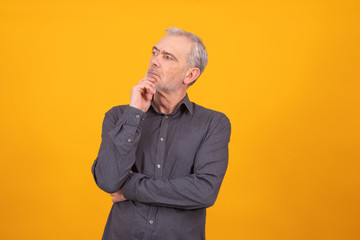 senior adult man isolated on color background thinking