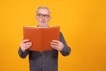 adult or senior man with book isolated on color background