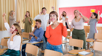 Wall Mural - Excited student group talking on phones