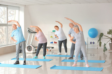 Elderly people exercising in gym