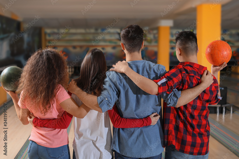 Friends playing bowling in club