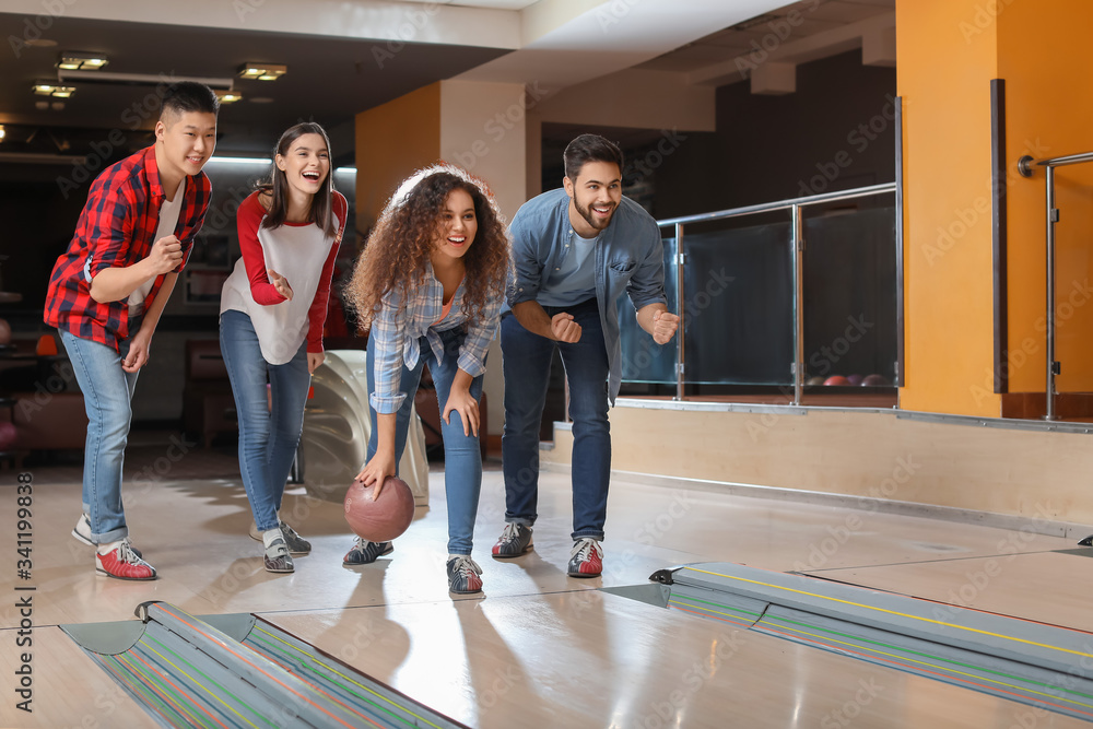 Friends playing bowling in club