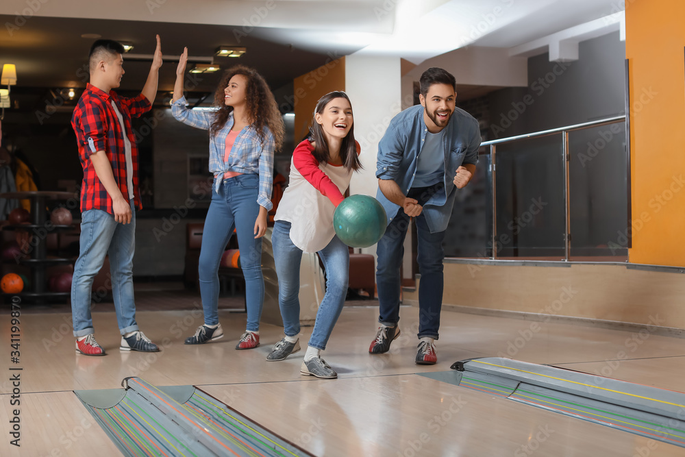 Friends playing bowling in club