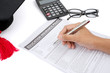 © Creativa Images - Closeup of hand filling education insurance form