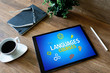 Tablet with languages courses text and icons on screen. English learning online. Education concept.