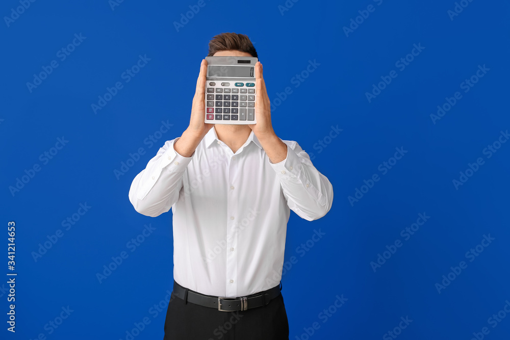 Young man with calculator on color background