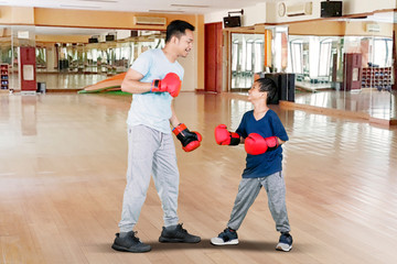 Sticker - Young man and little son doing boxing exercise