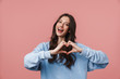 © Drobot Dean - Image of young woman smiling and showing heart shape with fingers