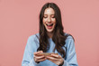 © Drobot Dean - Image of attractive young woman smiling and holding cellphone