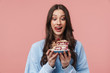 © Drobot Dean - Image of surprised young woman liking her lips while holding cake