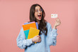© Drobot Dean - Image of young student girl holding exercise books and credit card