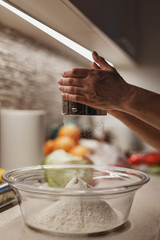 Wall Mural - Flour falling through sifting device into big trnsparent glass bowl