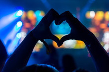 Cropped Hands Making Heart Shape Against Illuminated Lights