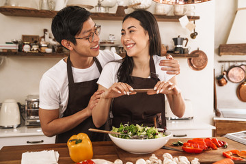 Poster - Image of couple taking photo on mobile phone while cooking dinner