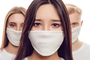 Wall Mural - Young people in protective face masks isolated on white.