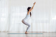 © Dusan Petkovic - Young attractive yogi girl standing in Chair yoga pose. Yoga studio interior.