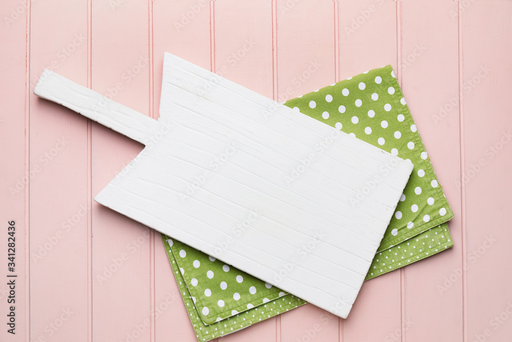 Clean napkin with cutting board on wooden background