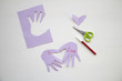 © Diana - Child made a greeting card. Step 7. Child holds a card in his hands. Tools and materials for children's art creativity on table. Mother's day or March 8 greeting card DIY idea.