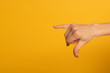 © LIGHTFIELD STUDIOS - Cropped view of woman using deaf and dumb language isolated on yellow