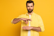 Man showing gesture in deaf and dumb language on yellow background