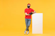 Delivery man in red cap t-shirt uniform sterile face mask gloves hold blank sign board isolated on yellow background studio Guy employee Service quarantine pandemic coronavirus virus 2019-ncov concept