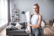 © BestForYou - Athletic woman with yoga mat indoors.