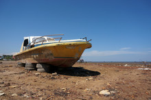 Old Abandoned Wrecked Speed Boat At Ship Or Boat Graveyard. Lots Of Different Dry Docked.   