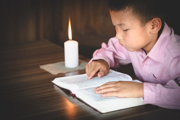 poor children read books using candles for lighting., disadvantaged children doing homework, educati