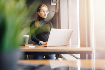 Young female businessman conducts business online computer home with coffee mug, while quarantine from coronavirus in country