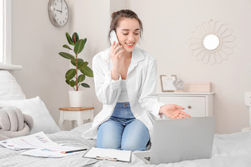 Canvas Print - Beautiful young woman working on laptop at home