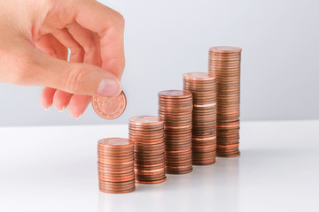 Saving money, business growth or investment concept. Hand and stacks of money coins