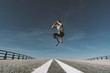 Disabled athlete with leg prosthesis jumping on a road