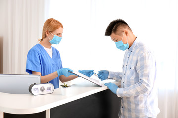 Wall Mural - Female receptionist working with patient in clinic