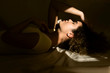 © Westend61 - Portrait of attractive young woman lying in bed in sunlight
