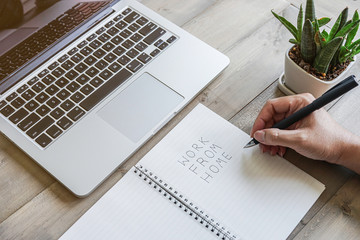 Work from home text with laptop computer and coffee on wooden background.