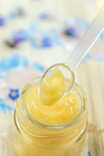 Raw Organic Royal Jelly In A Small Bottle With Litte Spoon On Small Bottle On Flower Background,