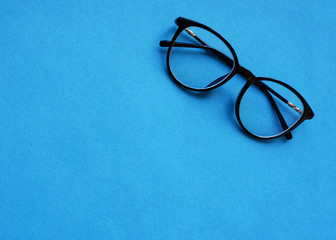 Classic glasses with a black rim on a blue background