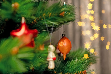 Decorated Christmas tree closeup. Red and golden balls and illuminated garland with flashlights. New Year baubles macro photo with bokeh. Winter holiday light decoration